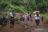 Sejumlah warga penyintas bencana banjir bandang dan longsor berjalan di sekitar hunian sementara (huntara) di Kampung Cigobang, Lebak, Banten, Senin (26/5/2025). Sebanyak 241 kepala keluarga (KK) yang merupakan korban bencana banjir bandang dan longsor pada tahun 2020 tersebut selama lima tahun masih bertahan di tenda huntara dengan akses yang sulit dijangkau dan mengharapkan pemerintah agar segera membangun hunian tetap (huntap) yang telah dijanjikan. ANTARA FOTO/Muhammad Bagus Khoirunas/gp