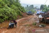 Warga mendorong motornya akibat jalan yang licin di kawasan hunian sementara (huntara) di Kampung Cigobang, Lebak, Banten, Senin (26/5/2025). Sebanyak 241 kepala keluarga (KK) yang merupakan korban bencana banjir bandang dan longsor pada tahun 2020 tersebut selama lima tahun masih bertahan di tenda huntara dengan akses yang sulit dijangkau dan mengharapkan pemerintah agar segera membangun hunian tetap (huntap) yang telah dijanjikan. ANTARA FOTO/Muhammad Bagus Khoirunas/gp