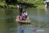 Siswa SDN Panaruban menyeberangi sungai Cicadas menggunakan rakit di Desa Karanganyar, Cililin, Kabupaten Bandung Barat, Jawa Barat, Selasa (27/5/2025). Sejumlah siswa dan warga dari Kampung Sampora serta Kampung Cijigud sejak tahun 1984 untuk sekolah atau mengakses pelayanan publik terpaksa menyeberangi sungai Cicadas menggunakan rakit guna memangkas waktu perjalanan menjadi 10 menit dibandingkan dengan jalur darat yang mencapai satu jam. ANTARA FOTO/Abdan Syakura/agr