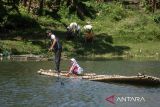 Siswa SDN Panaruban menyeberangi sungai Cicadas menggunakan rakit di Desa Karanganyar, Cililin, Kabupaten Bandung Barat, Jawa Barat, Selasa (27/5/2025). Sejumlah siswa dan warga dari Kampung Sampora serta Kampung Cijigud sejak tahun 1984 untuk sekolah atau mengakses pelayanan publik terpaksa menyeberangi sungai Cicadas menggunakan rakit guna memangkas waktu perjalanan menjadi 10 menit dibandingkan dengan jalur darat yang mencapai satu jam. ANTARA FOTO/Abdan Syakura/agr