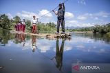 Siswa SDN Panaruban menyeberangi sungai Cicadas menggunakan rakit di Desa Karanganyar, Cililin, Kabupaten Bandung Barat, Jawa Barat, Selasa (27/5/2025). Sejumlah siswa dan warga dari Kampung Sampora serta Kampung Cijigud sejak tahun 1984 untuk sekolah atau mengakses pelayanan publik terpaksa menyeberangi sungai Cicadas menggunakan rakit guna memangkas waktu perjalanan menjadi 10 menit dibandingkan dengan jalur darat yang mencapai satu jam. ANTARA FOTO/Abdan Syakura/agr