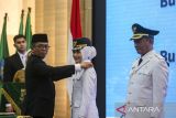 Gubernur Banten Andra Soni (ketiga kiri) menyematkan tanda pangkat kepada Bupati Kabupaten Serang Ratu Zakiyah (kedua kanan) didampingi Wakil Bupati Najib Hamas (kanan) saat pelantikan di Pendopo Gubernur Provinsi Banten, Kota Serang, Banten, Selasa (27/5/2025). Ratu Zakiyah dan Najib Hamas resmi dilantik sebagai Bupati dan Wakil Bupati Kabupaten Serang terpilih masa jabatan 2025-2030 setelah sebelumnya menang dalam Pemungutan Suara Ulang (PSU) Pilkada Kabupaten Serang 2024. ANTARA FOTO/Angga Budhiyanto/gp