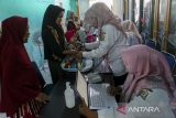 Petugas kesehatan menimbang berat badan bayi di Puskesmas Banten Girang, Kota Serang, Banten, Rabu (28/5/2025). Kementerian Keuangan mencatat realisasi anggaran pada sektor kesehatan sebesar Rp47,6 triliun atau mencapai 21,8 persen dari APBN hingga April 2025 yang digunakan untuk berbagai program seperti bantuan iuran Jaminan Kesehatan Nasional (JKN), pemberian vaksin imunisasi, pemberian makanan bergizi gratis bagi ibu hamil, ibu menyusui dan balita, serta pemeriksaan kesehatan gratis. ANTARA FOTO/Angga Budhiyanto/gp