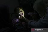 Petugas kesehatan memeriksa kondisi gigi seorang anak di Puskesmas Banten Girang, Kota Serang, Banten, Rabu (28/5/2025). Kementerian Keuangan mencatat realisasi anggaran pada sektor kesehatan sebesar Rp47,6 triliun atau mencapai 21,8 persen dari APBN hingga April 2025 yang digunakan untuk berbagai program seperti bantuan iuran Jaminan Kesehatan Nasional (JKN), pemberian vaksin imunisasi, pemberian makanan bergizi gratis bagi ibu hamil, ibu menyusui dan balita, serta pemeriksaan kesehatan gratis. ANTARA FOTO/Angga Budhiyanto/gp