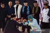 Rektor Institut Seni Budaya Indonesia (ISBI) Bandung Retno Dwimarwati (depan kanan) menerima golok dari pendekar silat Perguruan Cimande Didih (depan kiri) saat acara Ngadu Bako Mapag Program Studi Pencak Silat di Kampus ISBI Bandung, Jawa Barat, Rabu (28/5/2025). Kegiatan tersebut sebagai sosialisasi pencak silat yang diajukan sebagai program studi baru perkuliahan di Kampus ISBI Bandung untuk bagian pelestarian dan pembelajaran secara akademis terkait pencak silat yang telah menjadi Warisan Budaya Tak Benda Indonesia oleh UNESCO. ANTARA FOTO/Novrian Arbi/agr