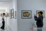 Pengunjung mengamati sebuah karya seni yang dipamerkan pada pameran lukisan yang bertemakan 