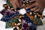 Perajin Sundari menjahit limbah tekstil berupa kain perca batik untuk dibuat aneka tas di rumah produksi Zigmarie, Tunjungsekar, Kota Malang, Jawa Timur, Jumat (30/5/2025). Menurut perajin aksesori fesyen tersebut tas dengan hiasan kain wastra nusantara seperti batik dan tenun, yang dibuat melalui proses daur ulang ramah lingkungan (upcycling), digemari pelanggan di Belanda, Turki maupun pasar dalam negeri dengan rata-rata penjualan per bulan mencapai 50 buah dengan harga antara Rp35 ribu hingga Rp250 ribu per buah tergantung kualitas. Antara Jatim/Ari Bowo Sucipto/um 