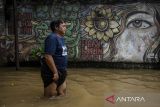 Warga berjalan melintasi banjir di Kampung Candulan, Cipondoh, Kota Tangerang, Banten, Jumat (30/5/2025). Banjir setinggi 30 - 50 cm tersebut akibat luapan Kali Angke yang dipicu tingginya intensitas hujan pada Kamis (29/5) malam. ANTARA FOTO/Putra M. Akbar/gp