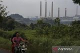 Pengendara sepeda motor melintas di sekitar lokasi Pembangkit Listrik Tenaga Uap (PLTU) Suralaya, Kota Cilegon, Banten, Jumat (30/5/2025). Menteri Energi dan Sumber Daya Mineral Bahlil Lahadalia menyampaikan rencana pembangunan PLTU sebesar 6,3 gigawatt (GW) dalam Rencana Usaha Penyediaan Tenaga Listrik (RUPTL) PLN 2025â2034 yang disebabkan lemahnya komitmen transisi energi global. ANTARA FOTO/Angga Budhiyanto/gp