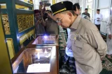 Menteri Kebudayaan Fadli Zon melihat Al Quran berusia 400 tahun saat mengunjungi Masjid Shiratal Mustaqiem di Samarinda, Kalimantan Timur, Jumat (30/5/2025). Dalam kunjungannya di masjid cagar budaya yang berdiri pada tahun 1881 tersebut Fadli Zon juga melaksanakan ibadah shalat jumat. Antara kaltim/M Risyal Hidayat