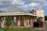Pekerja menyelesaikan pemasangan atap bangunan saat renovasi gedung bertingkat untuk Sekolah Rakyat di komplek Sekolah Unggul Ali Hasjmy, kabupaten Aceh Besar, Aceh, Minggu (1/6/2025). Kementerian Sosial (Kemensos) memproyeksikan sebanyak 100.000 anak dari keluarga miskin dan miskin ektrem  akan menjalani kegiatan belajar menyusul dibukanya sebanyak 100 Sekolah Rakyat  pada tahun ajaran baru Juli 2025 dengan kuota 1.000 siswa per Sekolah Rakyat. ANTARA FOTO/Ampelsa.