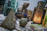 Pekerja menyatukan limbah kerang menggunakan lem untuk dijadikan produk lampu kerang di Gerai UMKM dan Rumah Produksi Banten, Kota Serang, Banten, Selasa (3/6/2025). Menteri Usaha Mikro Kecil dan Menengah (UMKM) Maman Abdurrahman menargetkan rasio kewisrausahaan nasional meningkat dari 3,1 persen menjadi 3,6 persen pada periode 2025 hingga 2029 sebagai upaya memperkuat ekosistem kewirausahaan di seluruh Indonesia sekaligus dapat membuka lapangan kerja baru. ANTARA FOTO/Muhammad Bagus Khoirunas/gp