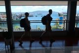 Dua orang yang akan menyeberang ke Bali melintas di jembatan pejalan kaki di Pelabuhan Ketapang, Banyuwangi, Jawa Timur,Kamis (5/6/2025). Untuk mendukung pemerintah dalam program stimulus ekonomi, PT ASDP Indonesia Ferry memberlakukan diskon jasa pelabuhan yang berdampak pada penurunan tarif tiket berkisar 19,14 persen hingga 40,19 persen di delapan Pelabuhan Indonesia. ANTARA Jatim/Budi Candra Setya/mas.