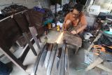 Perajin memotong lempengan mata gerinda bekas sebagai bahan baku pisau di Kelurahan Rejomulyo, Kota Kediri, Jawa Timur, Kamis (5/6/2025). Berbagai model pisau yang terbuat dari lempengan besi per truk dan mata gerinda bekas tersebut mampu diproduksi hingga 4 buah per hari dan dipasarkan melalui media sosial seharga Rp70 ribu hingga Rp4 juta per buah tergantung kualitas bahan dan ukuran.  ANTARA Jatim/Prasetia Fauzani/mas.