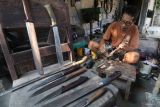 Perajin mengasah pisau yang terbuat dari besi per truk bekas di Kelurahan Rejomulyo, Kota Kediri, Jawa Timur, Kamis (5/6/2025). Berbagai model pisau yang terbuat dari lempengan besi per truk dan mata gerinda bekas tersebut mampu diproduksi hingga 4 buah per hari dan dipasarkan melalui media sosial seharga Rp70 ribu hingga Rp4 juta per buah tergantung kualitas bahan dan ukuran.  ANTARA Jatim/Prasetia Fauzani/mas.
