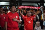 Sejumlah warga menyanyikan lagu Indonesia Raya sebelum menyaksikan pertandingan sepak bola antara Timnas Indonesia melawan China pada laga Kualifikasi Piala Dunia 2026 putaran ketiga Zona Asia melalui layar proyektor di Pendopo Kabupaten Lumajang , Jawa Timur, Kamis (5/6/2025). Pemkab Lumajang menggelar nonton bareng (nobar) sebagai dukungan kepada Timnas Indonesia yang menang atas China dengan skor 1-0. Antara Jatim/Irfan Sumanjaya/um
