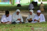 Sejumlah warga berdoa saat berziarah di kuburan massal  tsunami, Desa Ulee Lheue, Banda Aceh, Aceh, Jumat (6/6/2025). Ziarah kubur seusai melaksanakan shalat Idul Adha 1446 Hijriyah itu, untuk mendoakan keluarganya yang menjadi korban dalam peristiwa  bencana tsunami 2004 lalu. ANTARA FOTO/Ampelsa.