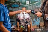 Panitia penyembelihan hewan kurban memberikan daging sapi yang telah di sembelih dari rumah ke rumah di Nyengseret, Bandung, Jawa Barat, Jumat (6/6/2025). Panitia penyembelihan hewan kurban Kecamatan Astanaanyar, Kelurahan Nyengseret berinisiatif untuk membagikan daging kurban dari rumah ke rumah untuk menghindari antrian yang berpotensi menimbulkan kericuhan. ANTARA FOTO/Raisan Al Farisi/agr
