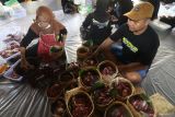Warga menimbang daging kurban dan mengemasnya menggunakan anyaman bambu (besek) yang dialasi dengan daun jati di Masjid Al-Khalid, Kota Kediri, Jawa Timur, Sabtu (7/6/2025). Pemanfaatan besek dan daun jati sebagai pembungkus daging kurban ramah lingkungan tersebut sebagai upaya mendukung program pemerintah meminimalisir penggunaan plastik. ANTARA Jatim/Prasetia Fauzani/mas.
