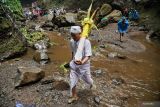Pemangku adat masyarakat Suku Tengger membawa air suci dalam wadah bambu saat ritual mendak tirta di air terjun Madakaripura Kabupaten Probolinggo, Jawa Timur, Minggu (8/6/2025). Ritual berdoa dan pengambilan air suci tersebut merupakan rangkaian jelang Upacara Yadnya Kasada bagi masyarakat Suku Tengger. Antara Jatim/Irfan Sumanjaya/mas