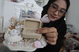 Perajin Galuh Yesty Ardhaneswari menghias hantaran pernikahan pesanan konsumennya di rumah produksi Uri Story, Ngawi, Jawa Timur, Senin (9/6/2025). Perajin berusia 27 tahun atau generasi Z tersebut mengandalkan media sosial sebagai pemasaran dan memasuki bulan Dzulhijah permintaan jasa persewaan hantaran pernikahan meningkat hingga empat kali lipat yakni dari 50 kotak menjadi 200 kotak per bulan dengan tarif sewa Rp50 ribu hingga Rp100 ribu per kotak tergantung hiasan. ANTARA Jatim/Ari Bowo Sucipto/mas.