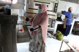 Pelaku Usaha Mikro Kecil Menengah (UMKM) Masyrifah Hidayati Nur (kiri) bersama pekerjanya membuat coklat tempe di rumah produksi Awicho, Danguk, Ngawi, Jawa Timur, Selasa (10/6/2025). Sebanyak 30 kilogram atau sekitar 900 batang coklat tempe diproduksi setiap hari di UMKM rumahan tersebut untuk kemudian diekspor ke Malaysia, Hongkong, Singapura maupun pasar domestik melalui pasar digital dengan harga Rp10 ribu hingga Rp90 ribu menurut ukuran serta varian rasa. Antara Jatim/Ari Bowo Sucipto/um