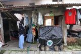Seorang warga penerima bantuan rehabilitasi rumah tidak layak huni (RTLH) menjemur pakaian di rumahnya di Kelurahan Tosaren, Kota Kediri, Jawa Timur, Selasa (10/6/2025). Pemerintah Kota Kediri memberikan bantuan rehabilitasi 161 RTLH masing-masing sebesar Rp20 juta guna mendukung program prioritas pemerintah pusat pada percepatan penanganan RTLH dengan target sebanyak tiga juta rumah secara nasional. Antara Jatim/Prasetia Fauzani/um