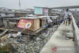 Warga berjalan di dekat permukiman kumuh di Kosambi, Kabupaten Tangerang, Banten, Selasa (10/6/2025). Badan Pusat Statistik (BPS) mencatat dalam rentang waktu sepuluh tahun terakhir jumlah penduduk miskin di Indonesia turun sekitar 3,06 juta orang menjadi 25,22 juta orang pada Maret 2024 atau menurun 2,22 persen dibandingkan Maret 2014 yang berjumlah 28,28 juta orang. ANTARA FOTO/Putra M. Akbar/gp