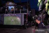 Warga menyaksikan pertandingan Kualifikasi Piala Dunia 2026 Zona Asia antara Timnas Indonesia melawan Jepang di Haur Pancuh, Bandung, Jawa Barat, Selasa (10/6/2025). Warga menggelar nonton bareng sebagai bentuk dukungan kepada Timnas Indonesia meskipun kalah dengan skor 0-6 pada pertandingan tersebut. ANTARA FOTO/Novrian Arbi/agr.
