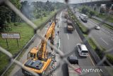Pekerja mengoperasikan alat berat menyelesaikan pemeliharaan perkerasan jalan di Tol Padaleunyi, Kota Cimahi, Jawa Barat, Rabu (11/6/2025). PT Jasamarga Metropolitan Tollroad (JMT) melakukan pemeliharaan perkerasan jalan di ruas Tol Cipularang dan Padaleunyi yang berlangsung hingga Jumat (13/6) sebagai upaya menjaga Standar Pelayanan Minimal (SPM) serta meningkatkan keamanan dan kenyamanan pengguna jalan. ANTARA FOTO/Abdan Syakura/agr