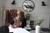 Pelaku usaha fesyen rumahan Febrina Fajarwati merancang busana di Gendhis Butik, Ngawi, Jawa Timur, Rabu (11/6/2025). Dalam sebulan pelaku usaha fesyen wastra rumahan tersebut mampu memproduksi sekitar 90 potong busana dengan gaya perkantoran atau office look dengan mengkombinasikan kain batik dan tenun untuk kemudian dijual ke berbagai kota di Indonesia melalui media sosial dengan harga Rp200 ribu hingga Rp1 juta per potong menurut kualitasnya. ANTARA Jatim/Ari Bowo Sucipto/mas.