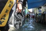 Sejumlah pelajar berjalan melintasi banjir robÂ  yang menggenangi kampung Kalianak Timur, Surabaya, Jawa Timur, Rabu (11/6/2025). Pasang air laut tinggi menyebabkan kampung padat penduduk tersebut tergenang banjir robÂ  dengan ketinggian bervariatif mulai 15 centimeter hingga 25 centimeter tergantung ketinggian permukaan jalan di kampung itu. ANTARA Jatim/Didik Suhartono/mas.