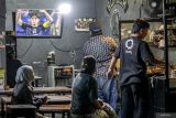 Warga menyaksikan pertandingan sepak bola antara Timnas Indonesia melawan Jepang pada laga Kualifikasi Piala Dunia 2026 putaran ketiga Zona Asia di Klojen, Malang, Jawa Timur, Selasa (10/6/2025).  Warga di sejumlah kampung, kafe, dan warung di kawasan itu menggelar nonton bareng sebagai dukungan kepada Timnas Indonesia meskipun kalah dengan skor 6-0 atas Jepang. ANTARA Jatim/Muhammad Mada/mas.