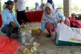 Warga menata sampah yang akan ditukarkan dengan sembako di taman wisata kawasan Blitar, Jawa Timur, Kamis (12/6/2025). Asosiasi bank sampah diwilayah itu menyiapkan berbagai paket sembako seperti gula, minyak goreng, telur dan lainnya dengan menukarkan sampah plastik yang dibawa oleh warga dalam rangka memperingati hari sampah sedunia. Antara Jatim/Irfan Anshori/um
