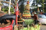 Peserta mengarak gunungan berisi hasil bumi saat peringatan Boyong Natapraja dan sedekah bumi di Nganjuk, Jawa Timur, Kamis (12/6/2025). Peringatan Boyong Natapraja atau perpindahan pusat pemerintahan dari Berbek ke Nganjuk pada tahun 1880 tersebut guna mengingatkan masyarakat tentang sejarah Nganjuk sekaligus perwujudan rasa syukur atas limpahan rezeki alam melalui tradisi sedekah bumi. ANTARA Jatim/Prasetia Fauzani/mas.