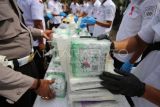 Personel Polda Aceh mengeluarkan narkotika jenis sabu (Metamfetamina) dari kemasan plastik sebelum pemusnahan di Banda Aceh, Kamis ( 12/6/2025). Polda Aceh memusnahkan barang bukti tindak kejahatan narkotika jenis ganja sebanyak 640 kilogram, sabu sebanyak 108 kilogram dan kokain sebanyak 25 kilogram hasil pengungkapan kasus Januari-Mei 2025, serta mengamankan empat tersangka dari sindikat jaringan internasional. ANTARA FOTO/Ampelsa/rwa. 
