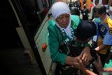 Personel TNI menggendong jamaah haji turun dari bus setibanya di Asrama Haji Sukolilo Surabaya, Surabaya, Jawa Timur, Kamis (12/6/2025). Sebanyak 376 jamaah haji kelompok terbang (kloter) 1 debarkasi Surabaya tiba di SurabayaÂ  setelah melaksanakan ibadah haji 1446 H di Arab Saudi. ANTARA Jatim/Didik Suhartono/mas.