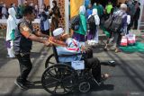 Jamaah haji berjalan menuju gedung Muzdalifah setibanya di Asrama Haji Sukolilo Surabaya, Surabaya, Jawa Timur, Kamis (12/6/2025). Sebanyak 376 jamaah haji kelompok terbang (kloter) 1 debarkasi Surabaya tiba di SurabayaÂ  setelah melaksanakan ibadah haji 1446 H di Arab Saudi. ANTARA Jatim/Didik Suhartono/mas.