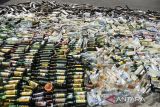 Botol berisi minuman keras dan knalpot bising yang dimusnahkan di Taman Kota Tasikmalaya, Jawa Barat, Jumat (13/6/2025). Pemerintah Kota Tasikmalaya memusnahkan 5.211 botol minuman keras dan 350 knalpot bising hasil operasi kegiatan rutin yang ditingkatkan (KRYD) di Kota Tasikmalaya selama dua bulan. ANTARA FOTO/Adeng Bustomi/agr
