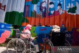 Warga penyandang disabilitas daksa melukis mural di Kampung Binong Jati, Bandung, Jawa Barat, Sabtu (14/6/2025). Kegiatan yang diinisiasi oleh Komunitas Masihan Indonesia tersebut untuk menyalurkan kreativitas perempuan penyandang disabilitas dalam memperindah dan mengenalkan kembali kawasan Binong Jati sebagai sentra rajut yang ada di Kota Bandung sehingga mampu kembali meningkatkan pertumbuhan ekonomi warga. ANTARA FOTO/Novrian Arbi/agr