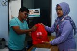 Petugas Palang Merah Indonesia (PMI) menyerahkan paket bingkisan kepada penderma saat kegiatan donor darah dalam rangka Peringatan Hari Donor Darah Sedunia di sekretariat Unit Donor Darah PMI Kota Madiun, Jawa Timur, Sabtu (14/6/2025). Dalam kegiatan tersebut PMI Kota Madiun menyediakan paket bingkisan untuk 100 pendonor pertama berisi beras, minyak goreng, minuman dalam botol dan makanan ringan. Antara Jatim/Siswowidodo/mas.