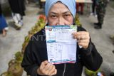Warga menunjukkan kartu pembelian saat akan membeli gas LPG 3 kilogram pada operasi pasar murah di Kantor Kecamatan Samarinda Ilir, Samarinda, Kalimantan Timur, Minggu (15/6/2025). Pemerintah Kota (Pemkot) Samarinda melalui Dinas Perdagangan bekerja sama dengan Pertamina menyediakan 11.720 tabung gas bersubsidi di 10 kecamatan yang dijual sesuai dengan harga Harga Eceran Tertinggi (HET) yakni Rp18 ribu per tabung. Antara Kaltim/M Risyal Hidayat