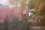 Pengunjuk rasa menyalakan suar saat mengikuti aksi solidaritas global march to Gaza di Jalan Asia Afrika, Bandung, Jawa Barat, Minggu (15/6/2025). Aksi yang diselenggarakan serentak di empat kota di Indonesia yaitu Jakarta, Bandung, Makassar, dan Malang tersebut merupakan bentuk solidaritas untuk gerakan Global March to Gaza yang bertepatan dengan ribuan warga lintas negara dalam persiapan memasuki wilayah Gaza guna memberikan bantuan kepada rakyat Palestina yang mengalami krisis akibat blokade dari Israel. ANTARA FOTO/Raisan Al Farisi/agr