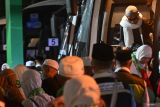 Jamaah haji turun dari bus disambut Panitia Penyelenggara Ibadah Haji (PPIH) untuk memasuki aula di Asrama Haji Embarkasi Banjarmasin di Banjarbaru, Kalimantan Selatan, Minggu (15/6/2025). Sebanyak 423 orang haji Kloter Pertama asal Banjarmasin tiba di Kalimantan Selatan usai melaksanakan ibadah haji dari Madinah. ANTARA/Tumpal Andani Aritonang
