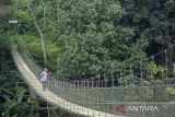 Warga berjalan di atas Jembatan Gantung Citarum di Cihampelas, Kabupaten Bandung Barat, Jawa Barat, Minggu (15/6/2025). Bupati Bandung Barat Jeje Ritchie Ismail menyatakan jembatan gantung yang memiliki panjang sekitar 100 meter dan menghubungkan Desa Pataruman dengan Desa Margaasih tersebut menjadi salah satu potensi ekowisata yang dapat dimanfaatkan serta dikelola oleh Koperasi Desa Merah Putih di wilayah itu. ANTARA FOTO/Abdan Syakura/agr