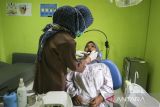 Petugas kesehatan memeriksa kondisi gigi warga saat cek kesehatan gratis di Puskesmas Banjar Agung, Kota Serang, Banten, Senin (16/6/2025). Berdasarkan data Kementerian Kesehatan yang dirilis pada 12 Juni 2025, sebanyak lebih dari 8,2 juta orang telah mengikuti program cek kesehatan gratis (CKG) sejak diluncurkan pada 10 Februari 2025, dengan rincian 62,2 persen merupakan peserta perempuan sementara laki-laki 37,7 persen. ANTARA FOTO/Angga Budhiyanto/gp