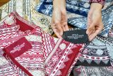Pekerja menunjukan kain batik yang dibuat menggunakan teknologi Artificial intelligence (AI) atau kecerdasan buatan di rumah produksi Batik Komar, Bandung, Jawa Barat, Senin (16/6/2025). Yayasan Batik Jawa Barat (YBJB), Asosiasi Perajin dan Pengusaha Batik Indonesia (APPBI), dan Yayasan Batik Indonesia (YBI) meluncurkan Kampung Batik AI di Batik Komar, Bandung sebagai tonggak awal transformasi batik tradisional melalui pendekatan teknologi kecerdasan buatan serta pemanfaatan teknologi AI dalam pengembangan desain batik. ANTARA FOTO/Raisan Al Farisi/agr