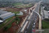 Foto udara kendaraan melintas di dekat proyek pembangunan akses tol langsung KM 25 Jakarta-Merak di Curug, Kabupaten Tangerang, Banten, Selasa (17/6/2025). Pembangunan akses tol sepanjang 10 KM dan Gerbang Tol Bitung 3 itu sebagai solusi mengatasi kemacetan di Jalan Arteri Bitung hingga 10-15 persen yang ditargetkan selesai akhir tahun 2025. ANTARA FOTO/Putra M. Akbar/gp