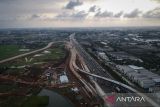 Foto udara kendaraan melintas di dekat proyek pembangunan akses tol langsung KM 25 Jakarta-Merak di Curug, Kabupaten Tangerang, Banten, Selasa (17/6/2025). Pembangunan akses tol sepanjang 10 KM dan Gerbang Tol Bitung 3 itu sebagai solusi mengatasi kemacetan di Jalan Arteri Bitung hingga 10-15 persen yang ditargetkan selesai akhir tahun 2025. ANTARA FOTO/Putra M. Akbar/gp