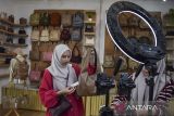 Pekerja melakukan siaran langsung saat mempromosikan tas produk Tweelyforbag di Kota Tasikmalaya, Jawa Barat, Selasa (17/6/2025). Pelaku usaha industri ekonomi kreatif (ekraf) Tweelyforbag yang berdiri sejak tahun 2015 itu memproduksi tas, dompet, poch pensil dan make up, yang dipasarkan melalui platform digital dan diekspor ke Malaysia dan Filipina. ANTARA FOTO/Adeng Bustomi/agr
